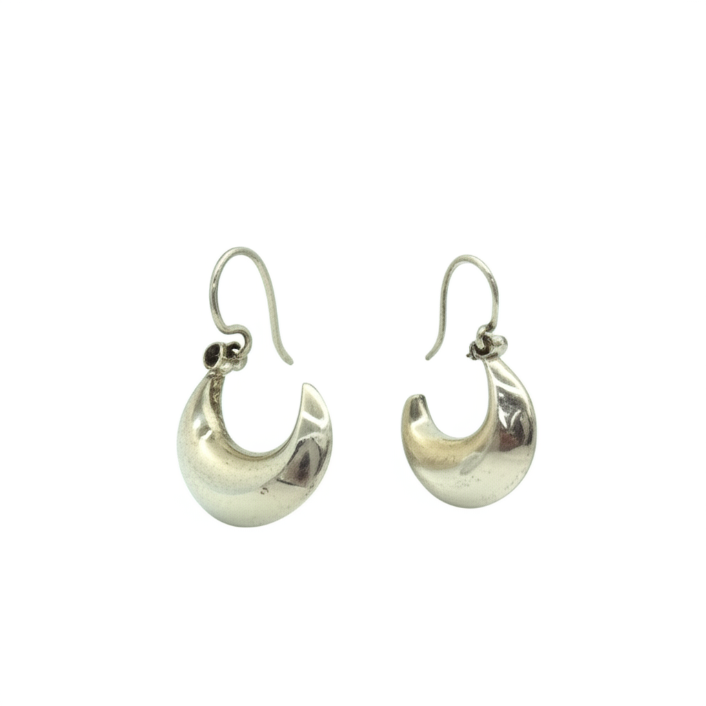A side view of a single sterling silver teardrop hoop earring, highlighting the unique, curved crescent shape and the secure clasp.