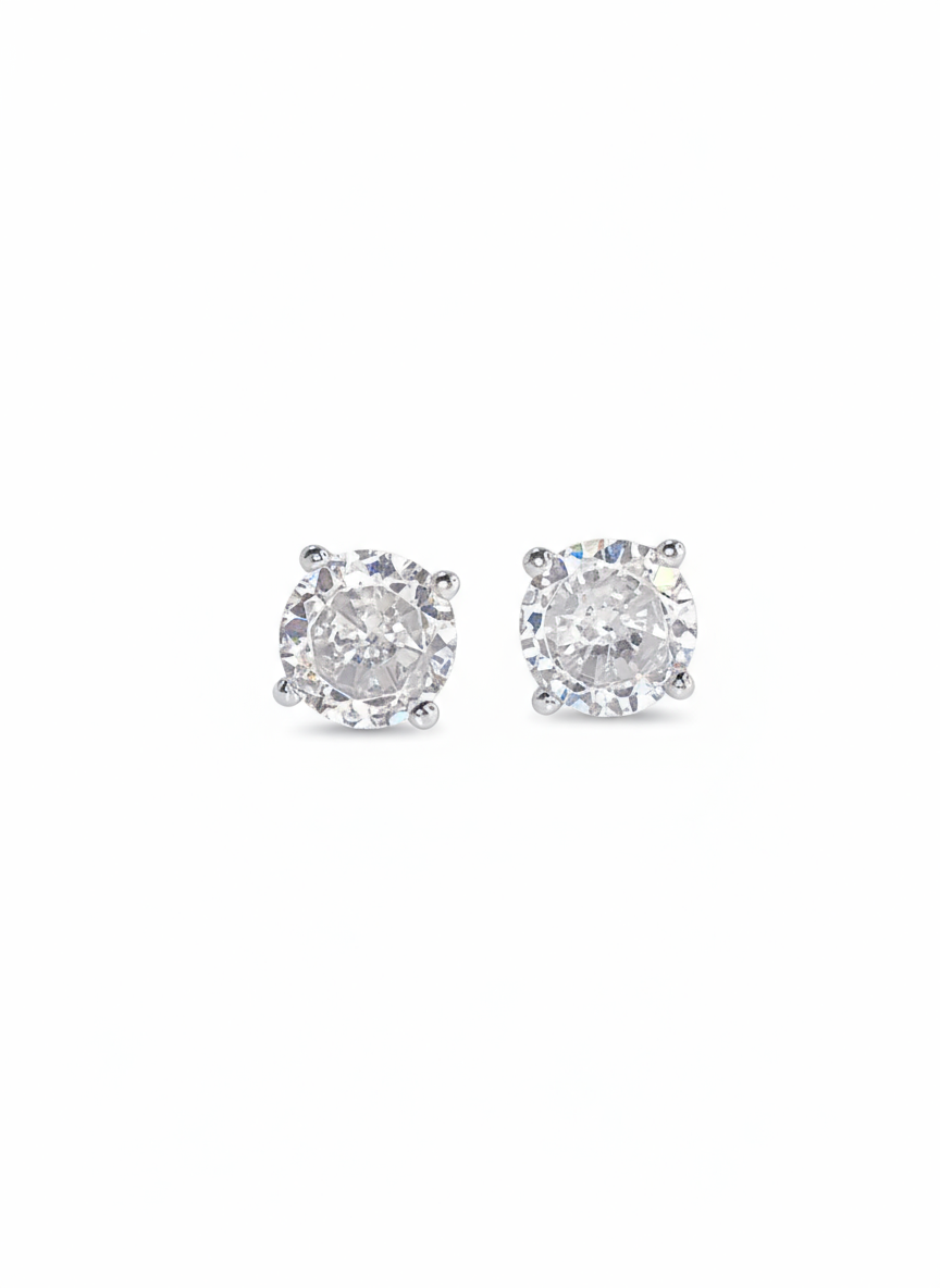 A pair of sterling silver stud earrings with a clear, brilliant round-cut stone in a four-prong setting, shown side-by-side against a white background.