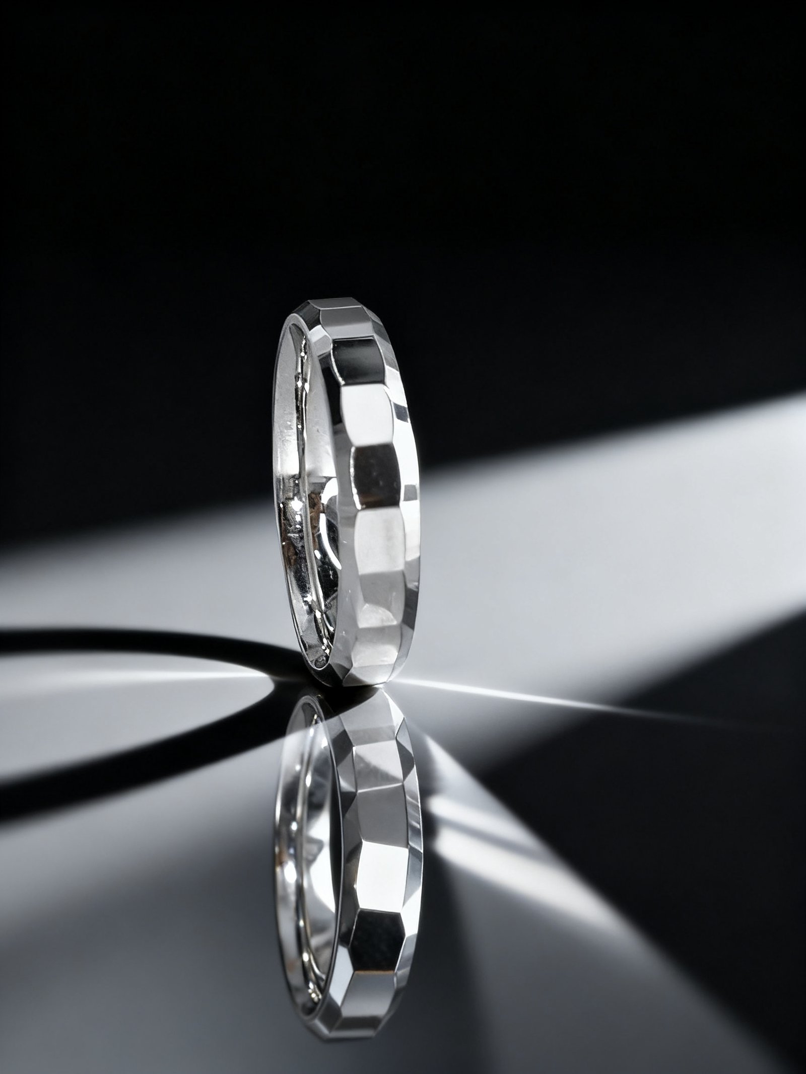 A sterling silver unisex wedding band with a textured, multi-faceted design and a high-polish finish.