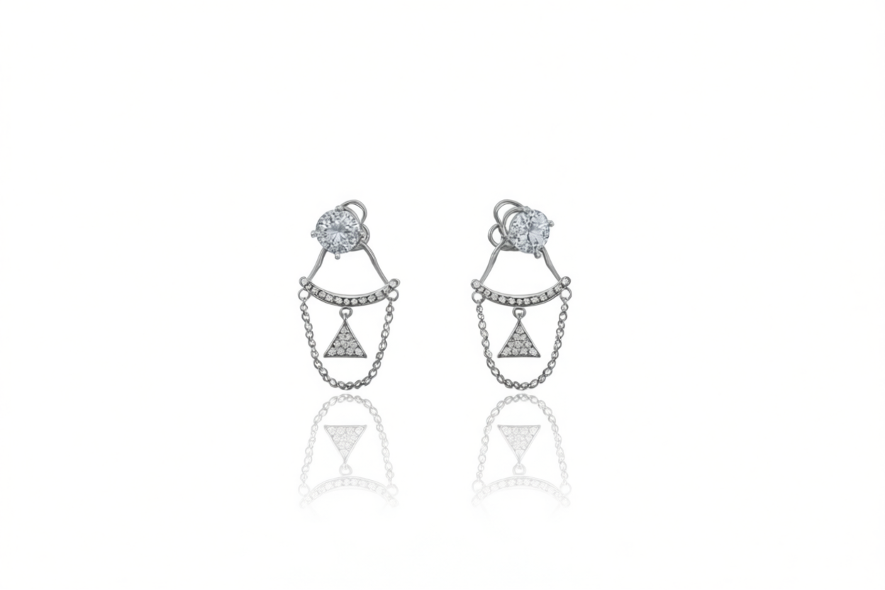 A pair of sterling silver ear jacket earrings with a round cubic zirconia stone and a chain connecting to a pavé-encrusted triangle.