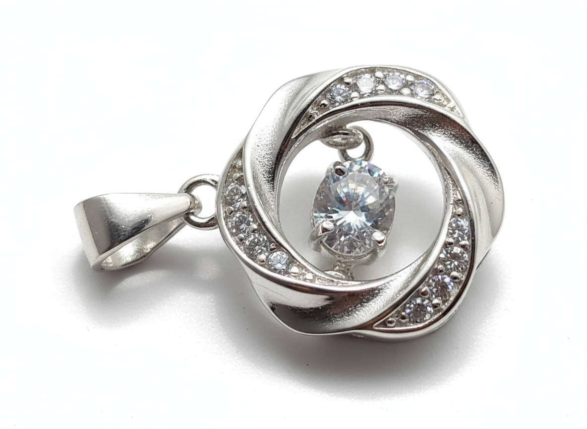 Close-up of The Sterling Reactor pendant, featuring a round-cut, brilliant, dancing cubic zirconia stone set within a swirling sterling silver halo with pave accents.