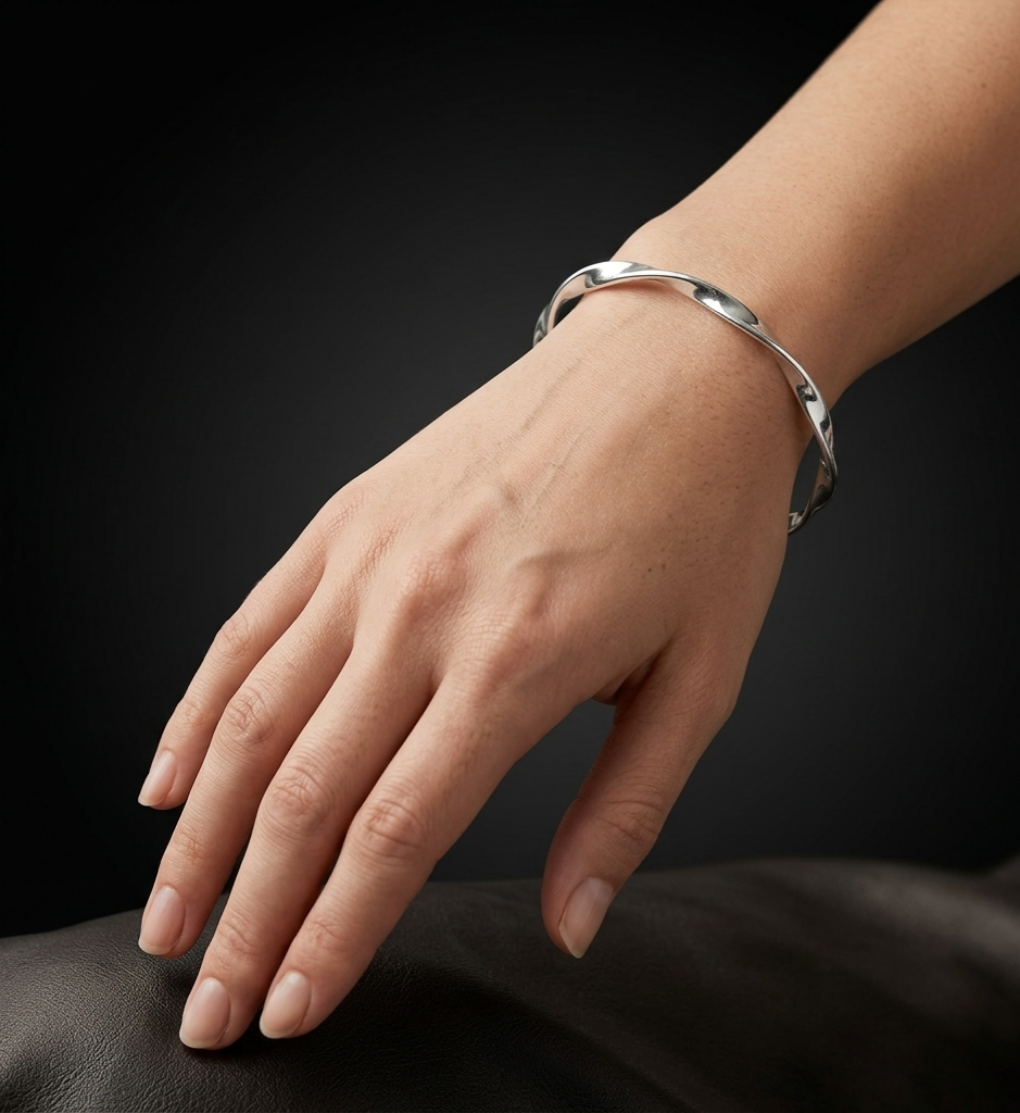Twisted Tempo 925 sterling silver bangle with a polished twisted design, elegantly styled on a woman's wrist against a dark luxury background