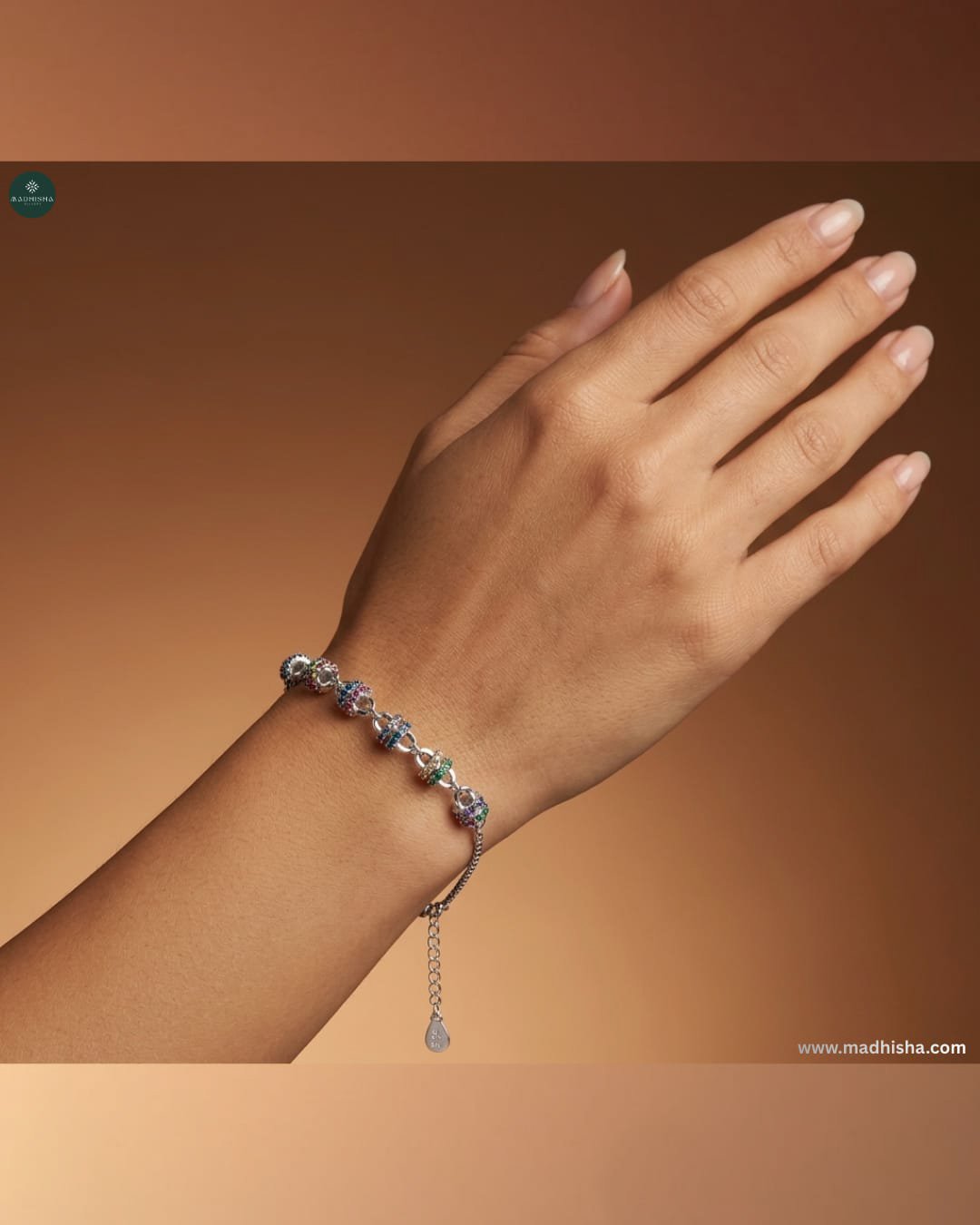 Woman wearing Madhisha Rainbow Bloomé sterling silver bracelet featuring colourful floral charm accents and adjustable chain.